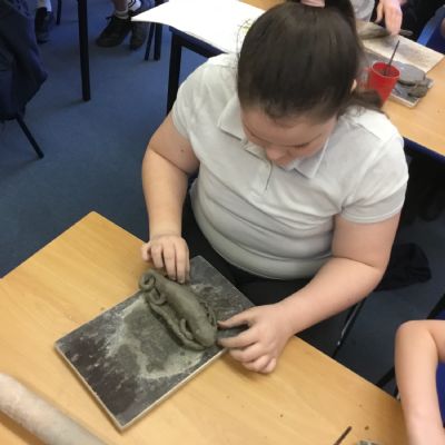 Children making clay lizards